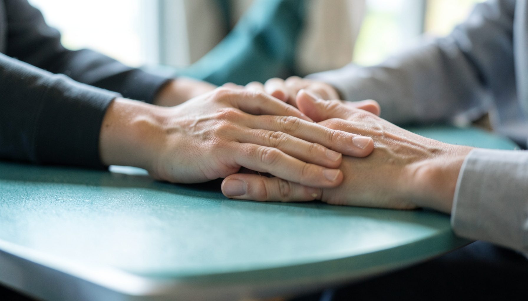 A close-up of hands resting on a roundtable discussion setting, natural daylight, collaborative mood