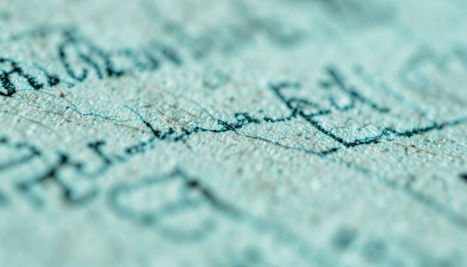 An extreme close-up photograph of aged paper fibers and ink, suggesting a historical document or publication