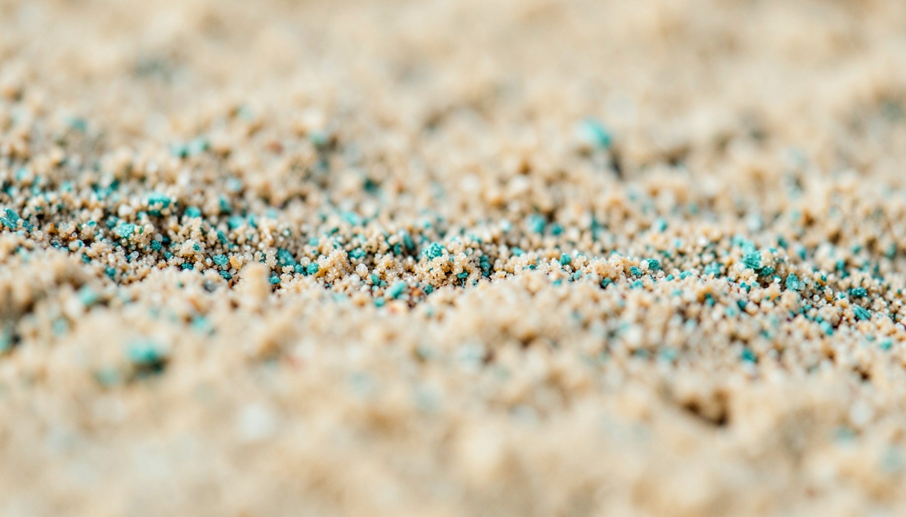 An extreme close-up of sandy textured surface, warm beige tones, evoking a Mediterranean or North African setting