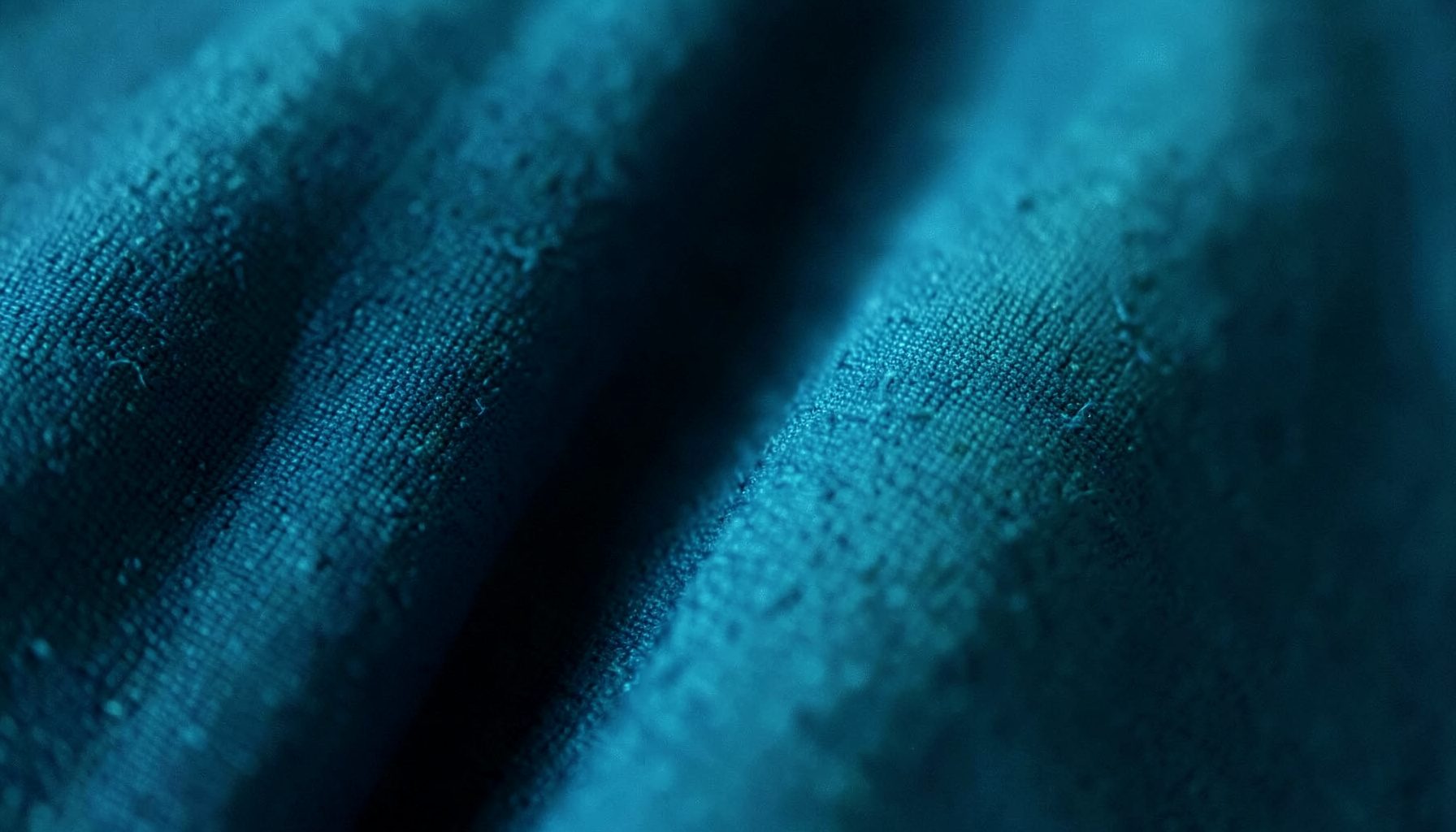 An extreme close-up of a stage curtain fabric in deep blue, formal congress atmosphere