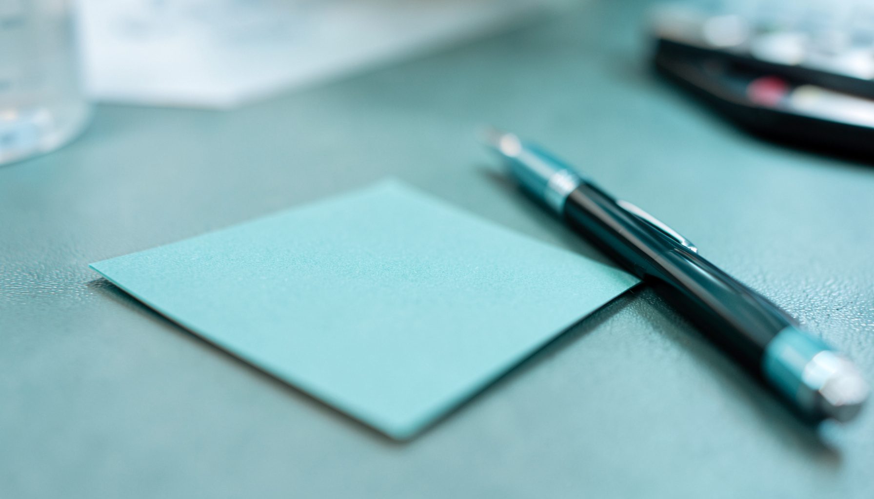 A close-up of a business card and pen on a meeting table, networking atmosphere